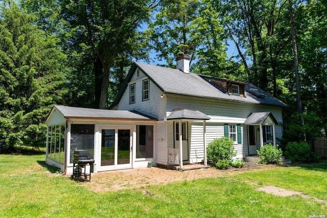 back of house with a sunroom and a yard