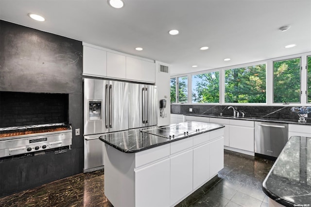 18 Hicks Ln, Sands Point, NY 11050 - kitchen with appliances with stainless steel finishes, a sink, dark stone counters, recessed lighting, and a kitchen island
