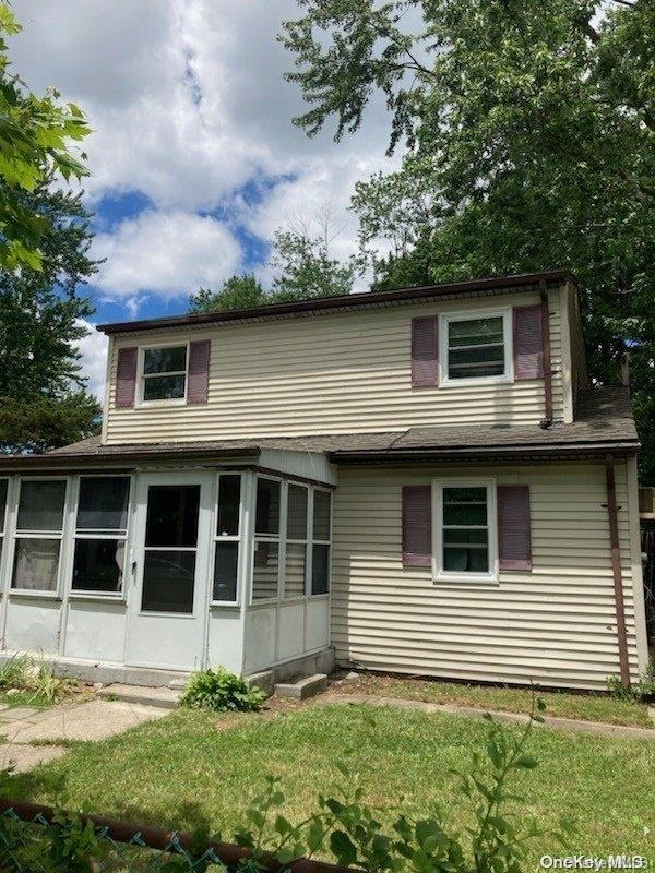 33 E Cherry St, Central Islip, NY 11722 - back of property featuring a sunroom and a yard