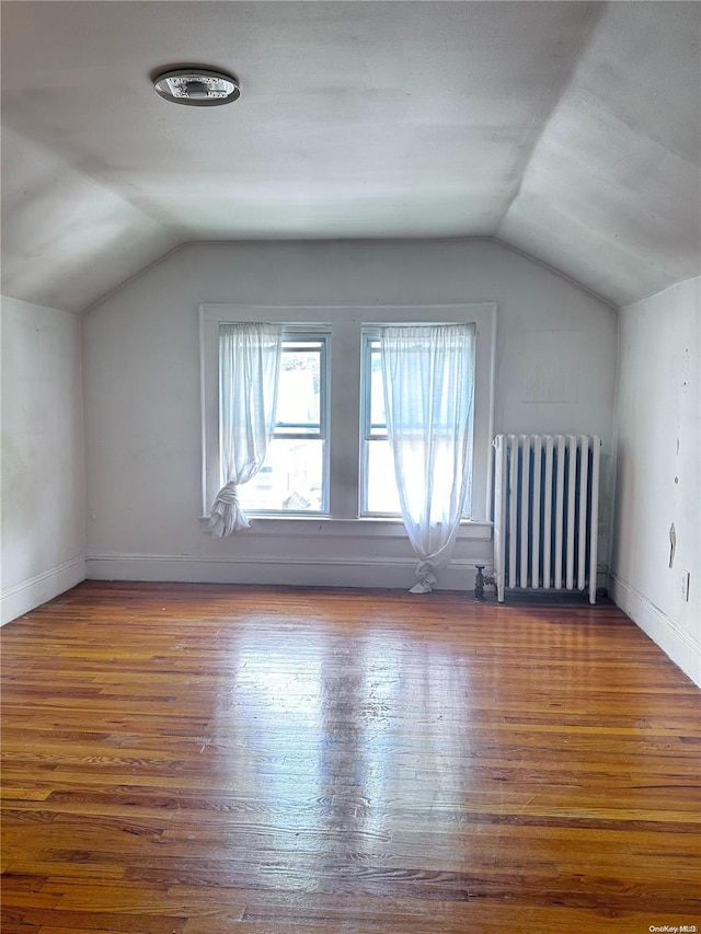 bonus room featuring radiator, lofted ceiling, and wood-type flooring