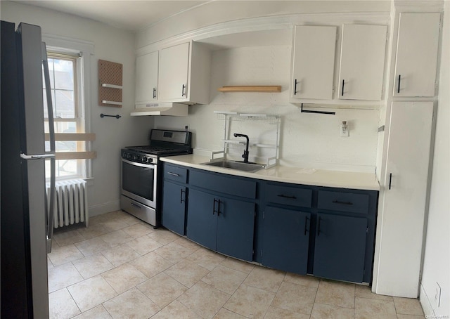 kitchen featuring white cabinets, radiator, blue cabinetry, sink, and gas range