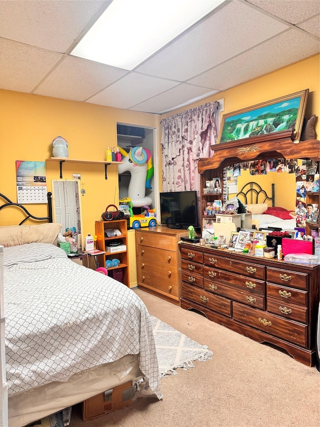 carpeted bedroom with a drop ceiling