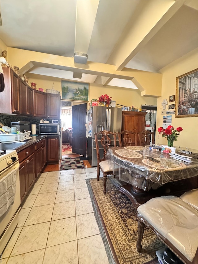 kitchen featuring tasteful backsplash, stainless steel appliances, and light tile patterned flooring