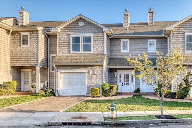 16 Ocean Watch Ct Unit 16, Freeport, NY 11520 - townhome / multi-family property with a chimney, a shingled roof, and a garage