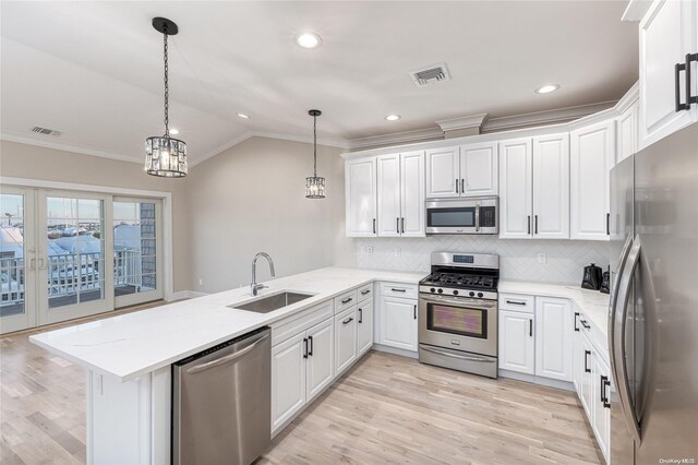 kitchen with pendant lighting, kitchen peninsula, sink, and appliances with stainless steel finishes