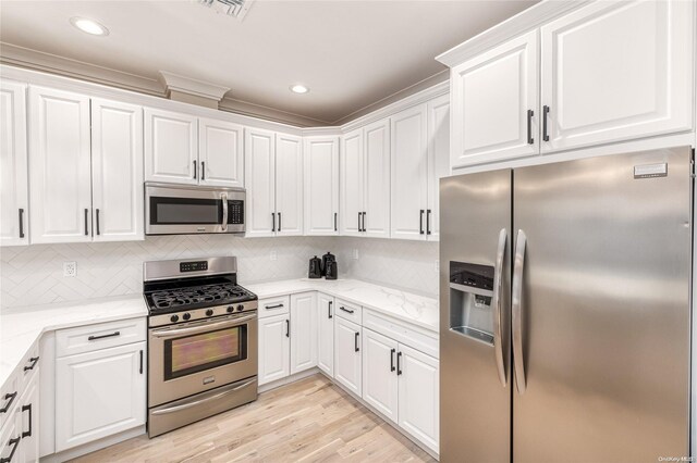 kitchen featuring backsplash, white cabinets, light hardwood / wood-style flooring, light stone countertops, and stainless steel appliances