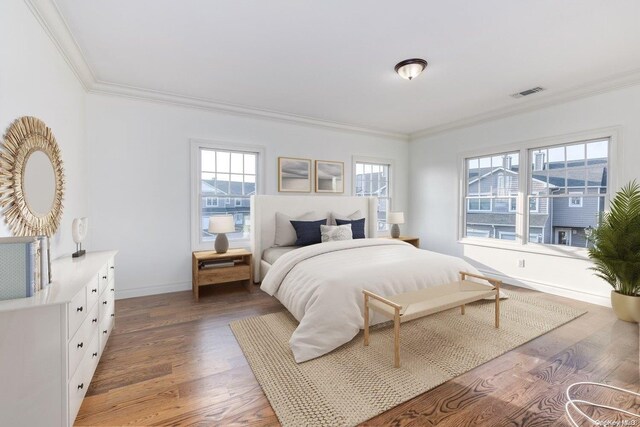 bedroom featuring crown molding and dark wood-type flooring