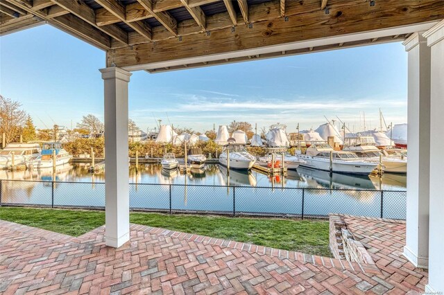 view of patio with a water view and a dock