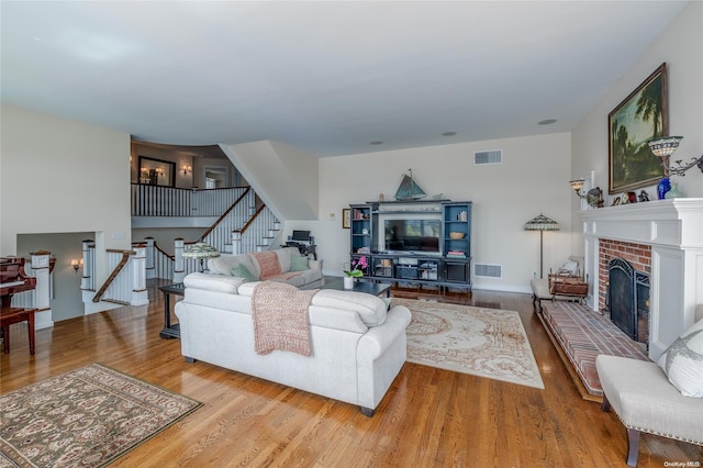 living room featuring light wood-type flooring and a fireplace