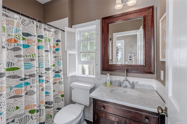 bathroom featuring vanity, toilet, tile walls, and curtained shower