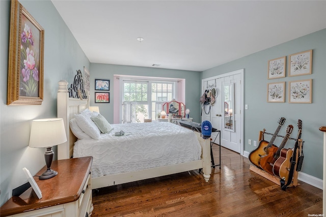 bedroom with dark hardwood / wood-style flooring