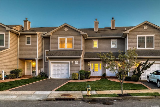 multi unit property featuring a front yard and a garage