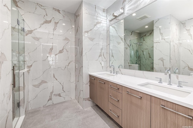 bathroom with vanity, tile walls, and a shower with shower door