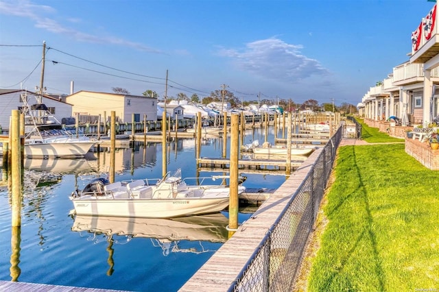 view of dock featuring a lawn and a water view