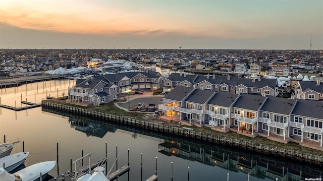 aerial view at dusk featuring a water view