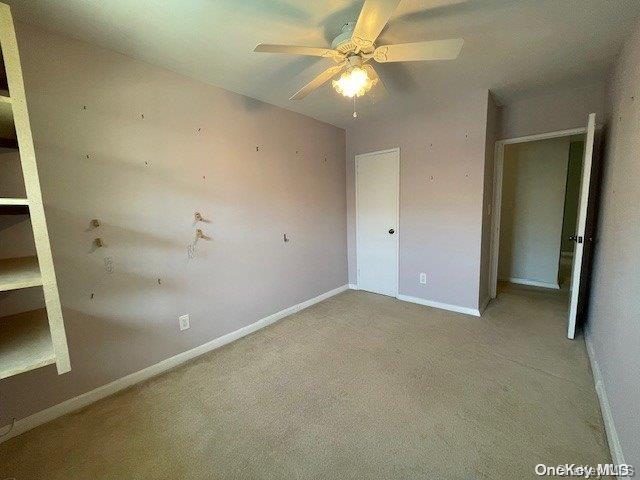 unfurnished bedroom with ceiling fan and light colored carpet