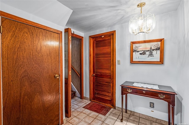 hallway featuring light tile patterned floors and an inviting chandelier