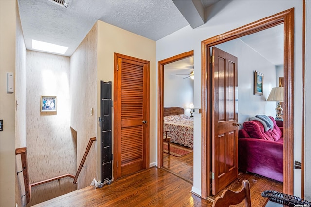 corridor featuring dark hardwood / wood-style floors and a textured ceiling