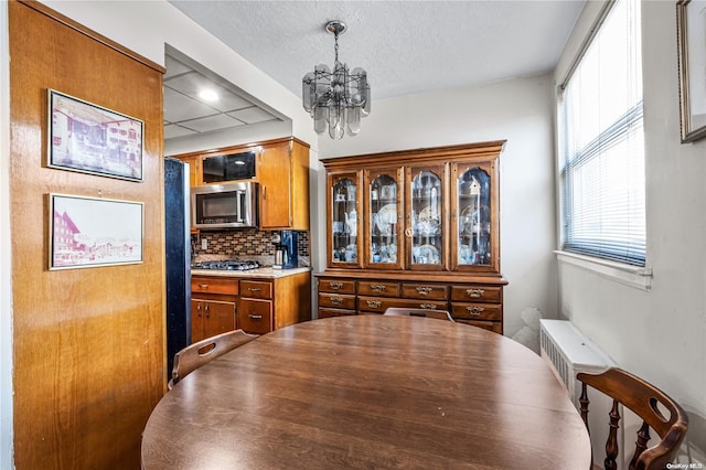 dining room featuring a textured ceiling and a notable chandelier