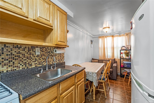 kitchen with tasteful backsplash, dark tile patterned flooring, ornamental molding, and sink