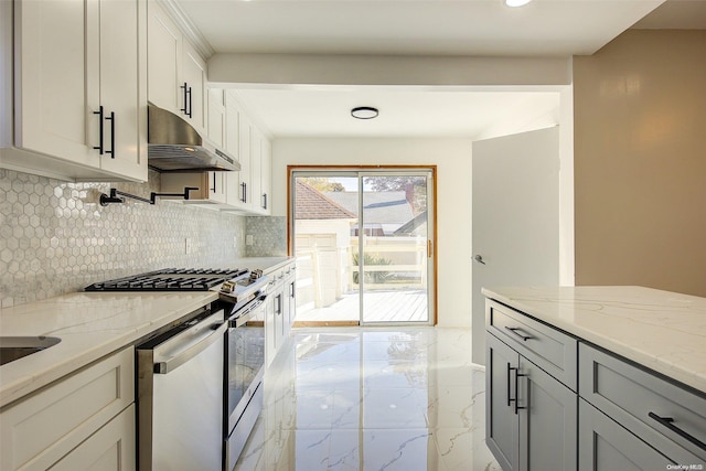 kitchen featuring white cabinets, backsplash, stainless steel appliances, and light stone counters