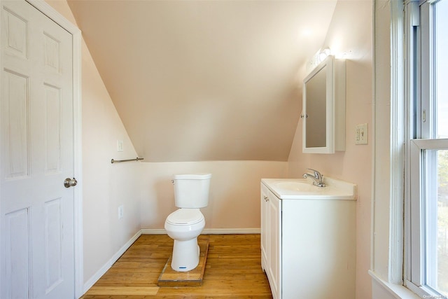 bathroom featuring toilet, vanity, lofted ceiling, and hardwood / wood-style flooring