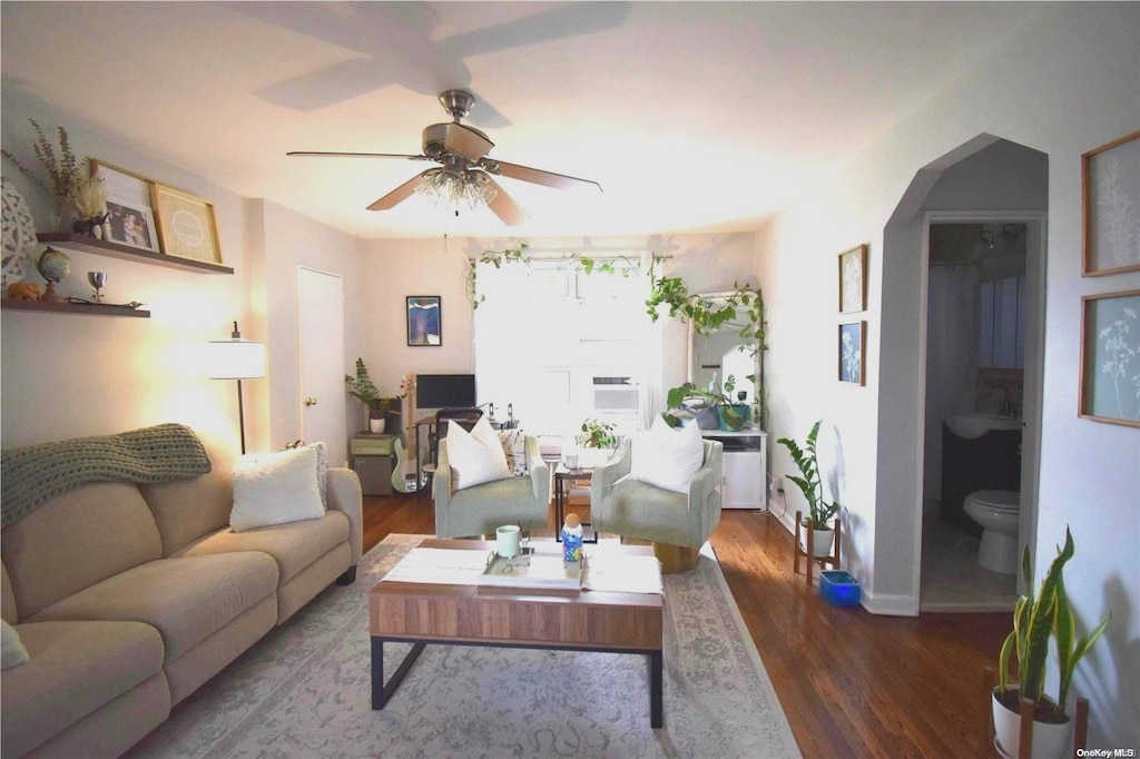 living room with dark hardwood / wood-style floors and ceiling fan