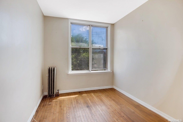 unfurnished room featuring radiator and wood-type flooring