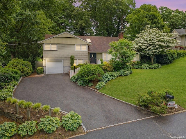 view of front facade featuring a garage and a lawn