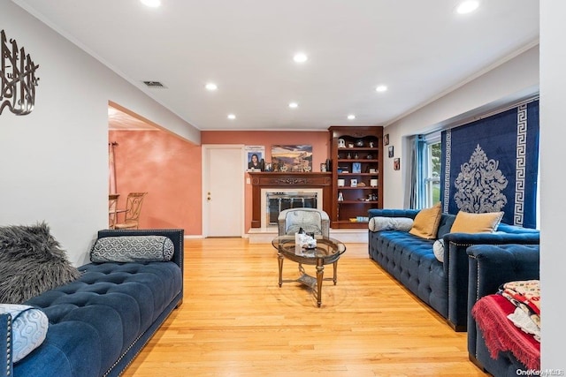 living room with light hardwood / wood-style flooring and crown molding