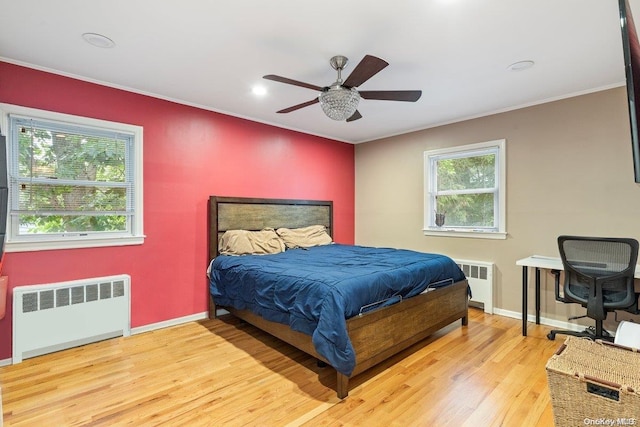 bedroom with ceiling fan, radiator heating unit, crown molding, and light hardwood / wood-style flooring