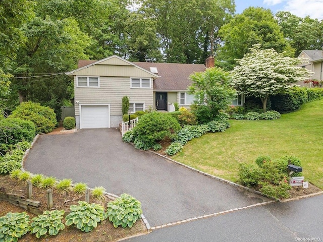 view of front of home with a garage and a front lawn