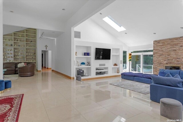 tiled living room featuring a fireplace, built in shelves, and high vaulted ceiling