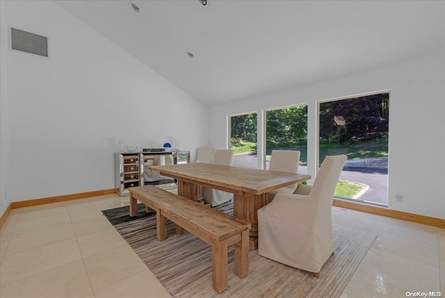 dining room featuring light tile patterned floors and high vaulted ceiling