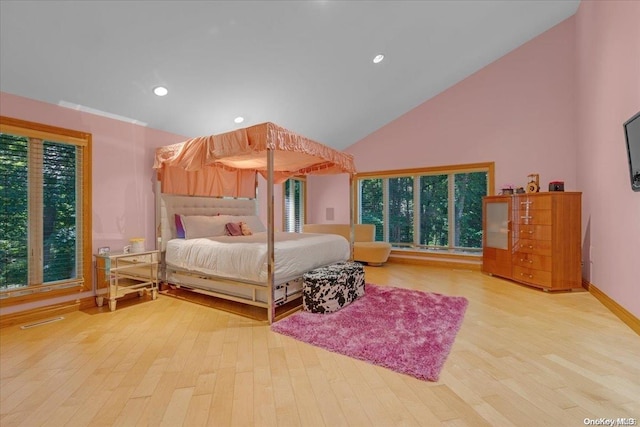 bedroom with light wood-type flooring, high vaulted ceiling, and multiple windows