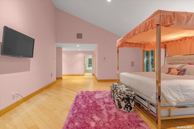 bedroom featuring hardwood / wood-style floors and high vaulted ceiling