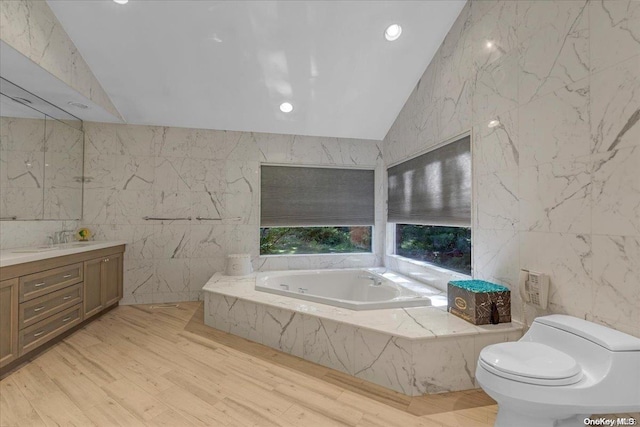 bathroom featuring vaulted ceiling, hardwood / wood-style flooring, a relaxing tiled tub, toilet, and tile walls