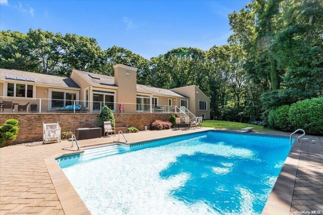 view of pool with a diving board and a patio area