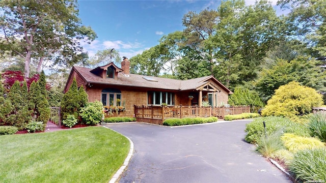 view of front of house featuring a deck and a front lawn