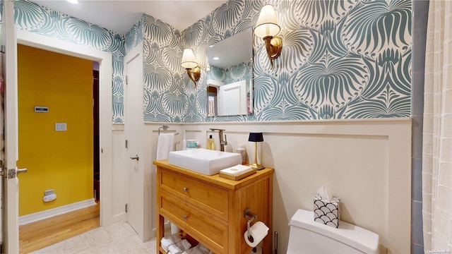 bathroom with hardwood / wood-style flooring, vanity, and toilet