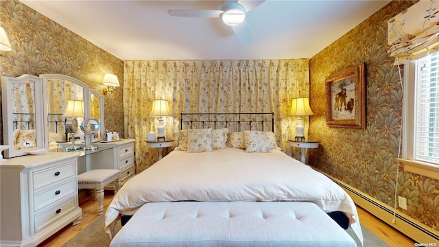 bedroom featuring ceiling fan, wood-type flooring, and a baseboard radiator