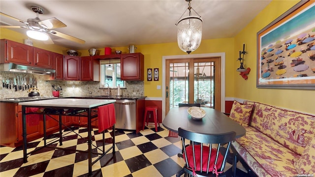 kitchen featuring tasteful backsplash, a wealth of natural light, dishwasher, and ceiling fan with notable chandelier