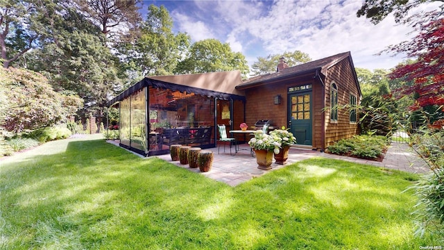 rear view of house with a yard and a patio