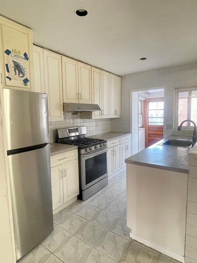 kitchen featuring appliances with stainless steel finishes, backsplash, and sink