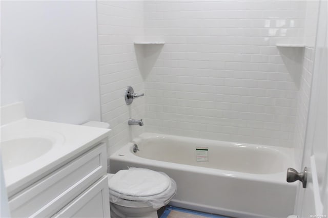 full bathroom featuring tiled shower / bath combo, toilet, and vanity