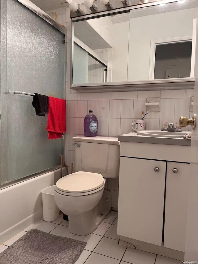 full bathroom featuring decorative backsplash, tile patterned floors, vanity, shower / bath combination with glass door, and toilet