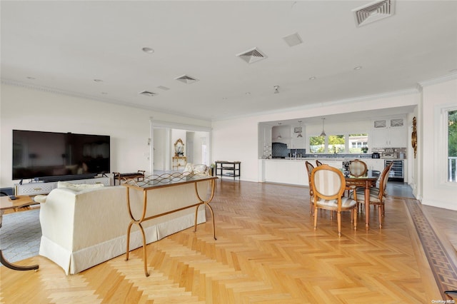 living room with light parquet flooring, beverage cooler, and crown molding