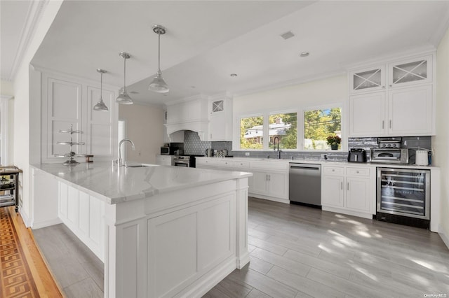 kitchen with wine cooler, white cabinets, and appliances with stainless steel finishes