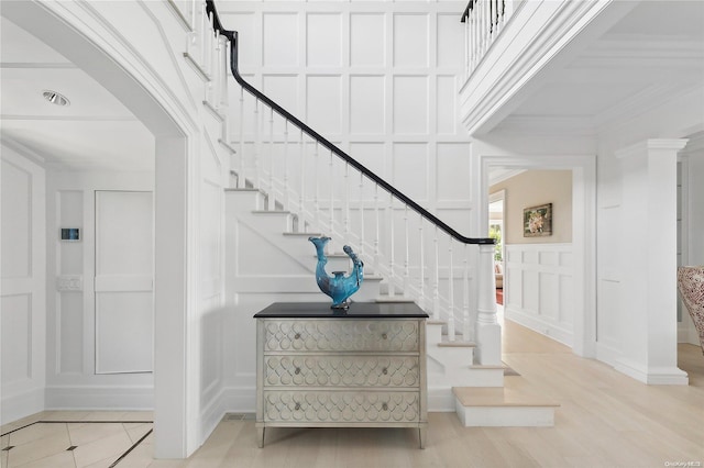 stairway featuring hardwood / wood-style floors and crown molding