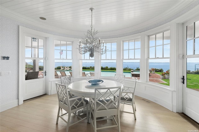 sunroom / solarium featuring a water view, wooden ceiling, a wealth of natural light, and a chandelier